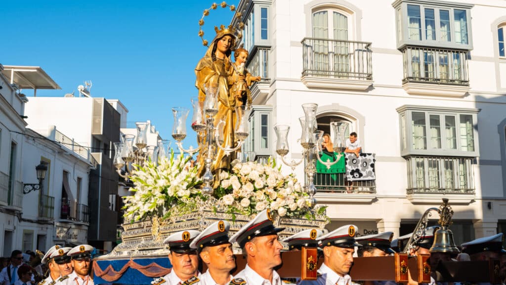 people participating in the celebration of the Catholic ceremony of transferring the holy figure. The 'Virgen del Carmen' is the patron saint and protector of fishermen